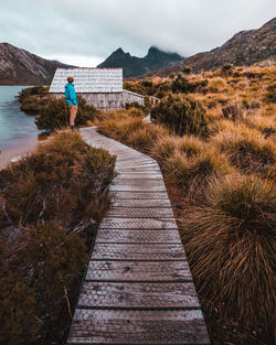 People on shore by sea against sky