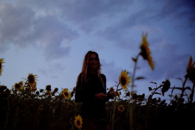 Woman standing on field against sky