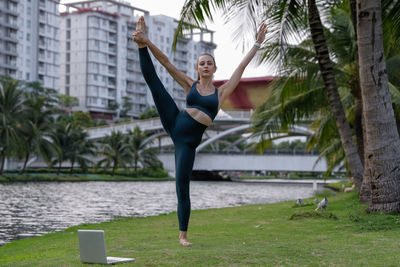 Full length of young woman jumping in park