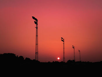 Silhouette street light against orange sky