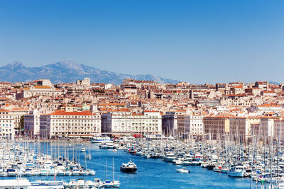 Aerial view of townscape by sea against clear sky