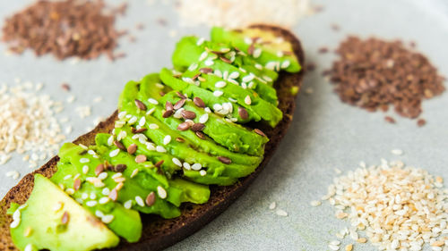 Healthy avocado toast on concrete background. wholegrain bread, sesame flax seeds. vegan keto diet. 