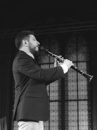 Man playing clarinet while standing at studio