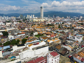 Aerial view of cityscape against cloudy sky