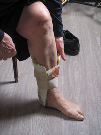 Senior caucasian woman wearing ankle orthosis or brace or left foot