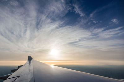 Aircraft's wing with beautiful sky from plane's window seat view.