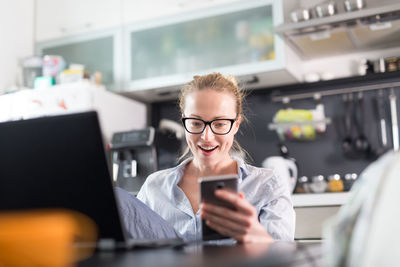 Business woman using smart phone while sitting at home