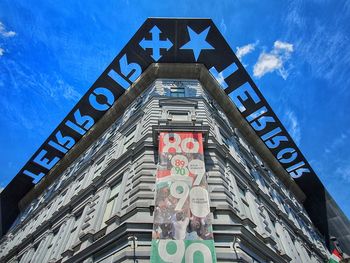 Low angle view of text on building against sky