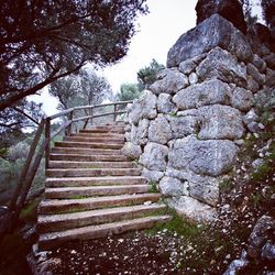 Low angle view of staircase against stone wall