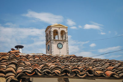 Low angle view of cross on roof of building against sky