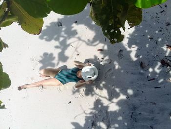 Directly above shot of woman lying down on beach