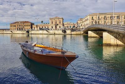 Boats in sea against buildings in city, siracusa italy