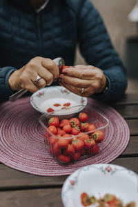 Woman's hands hulling strawberries