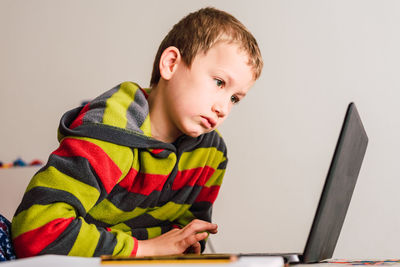 Cute boy looking at laptop