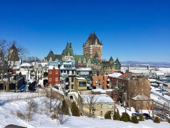 Buildings in city against clear blue sky