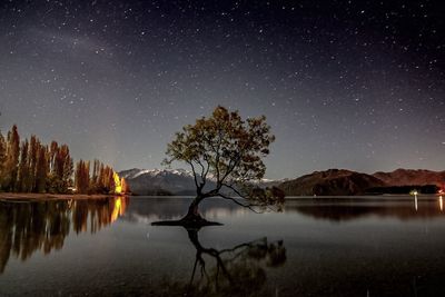 Scenic view of lake against sky at night