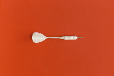 Dart on a red background. top view. flat lay.