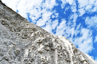 Low angle view of rocks against blue sky