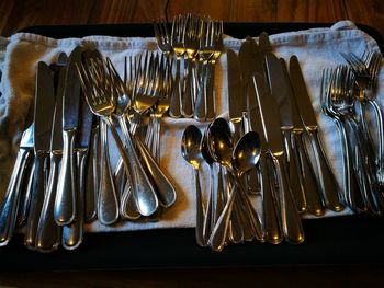 High angle view of silverware on napkin over table