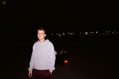 Portrait of young man standing at night