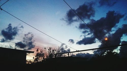 Low angle view of silhouette trees against sky