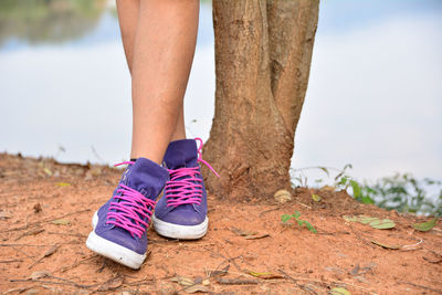 Low section of woman standing by lake