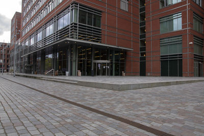 Footpath by street against buildings in city