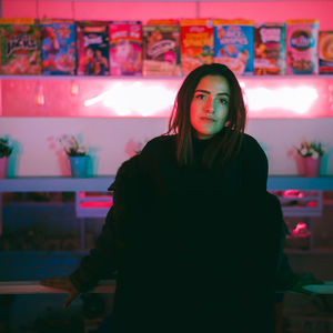 Portrait of woman standing against illuminated building