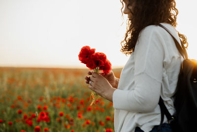 Midsection of woman holding flower