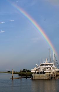 Scenic view of rainbow over sea against sky