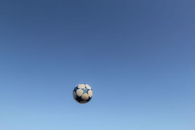 Low angle view of soccer ball against blue sky