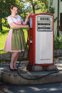 Portrait of woman in dirndl standing at gas station