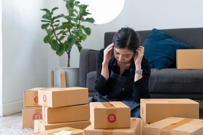 Side view of young woman sitting on sofa at home