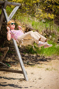 Senior woman joyfully swinging on a swing and having fan.