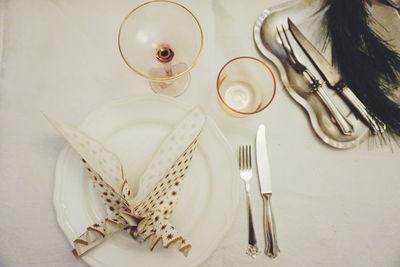 High angle view of napkin in plate with wineglasses on table