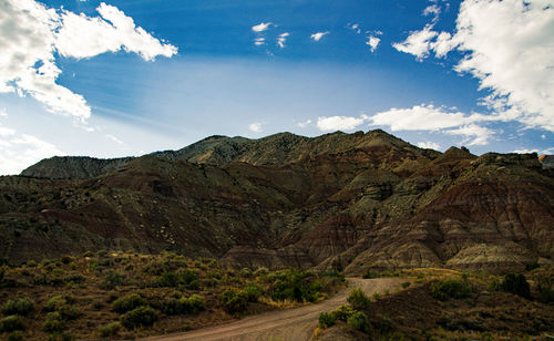Scenic view of road by mountains against sky