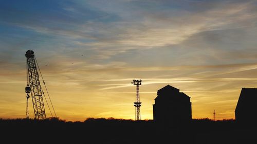 Low angle view of silhouette built structure against sky at sunset