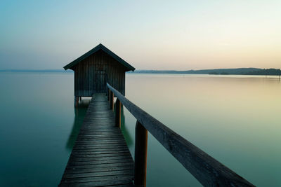 Wooden pier over sea against clear sky