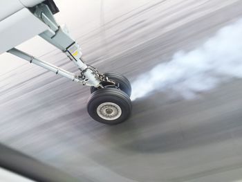 High angle view of smoke emitting from airplane wheel while landing on runway