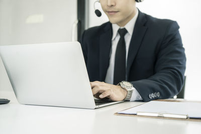 Midsection of man using mobile phone