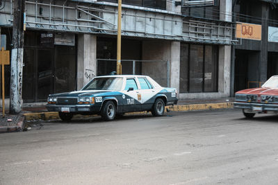 Side view of car on road against buildings