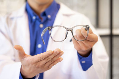 Midsection of doctor holding stethoscope