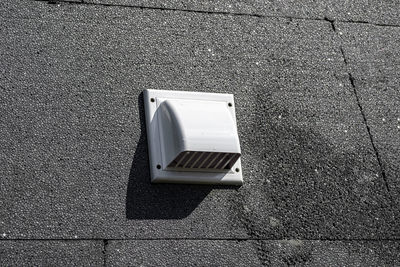 A plastic ventilation grille on the building facade made of black insulating styrofoam.