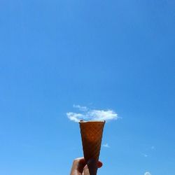 Cropped image of hand holding blue white background