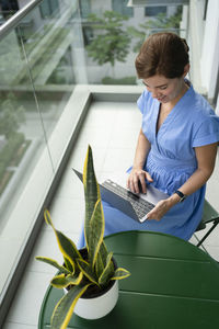 Smiling freelancer working on laptop in balcony