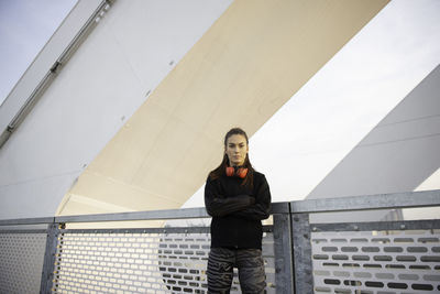 Portrait of young man standing against wall