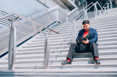 Full length of man sitting on staircase