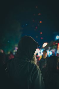 Rear view of people enjoying music concert at night