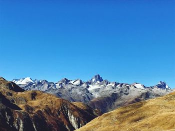 Scenic view of snowcapped mountains against clear blue sky