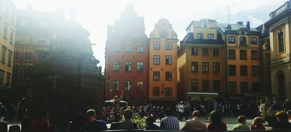 Crowd in city against sky